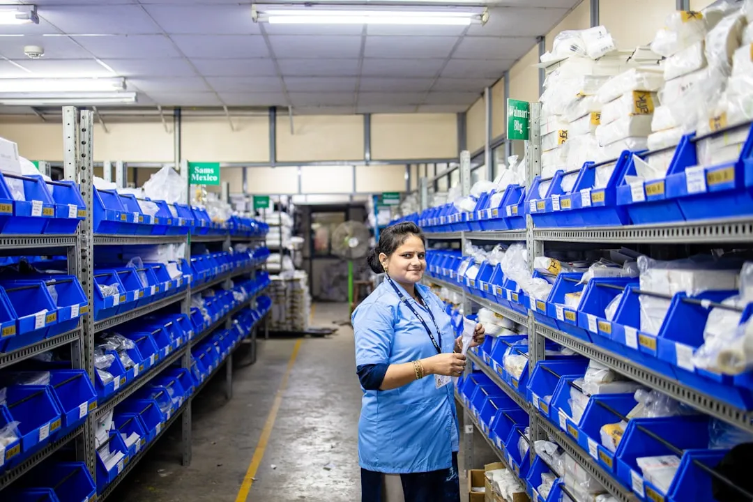 A woman works in an organized warehouse.