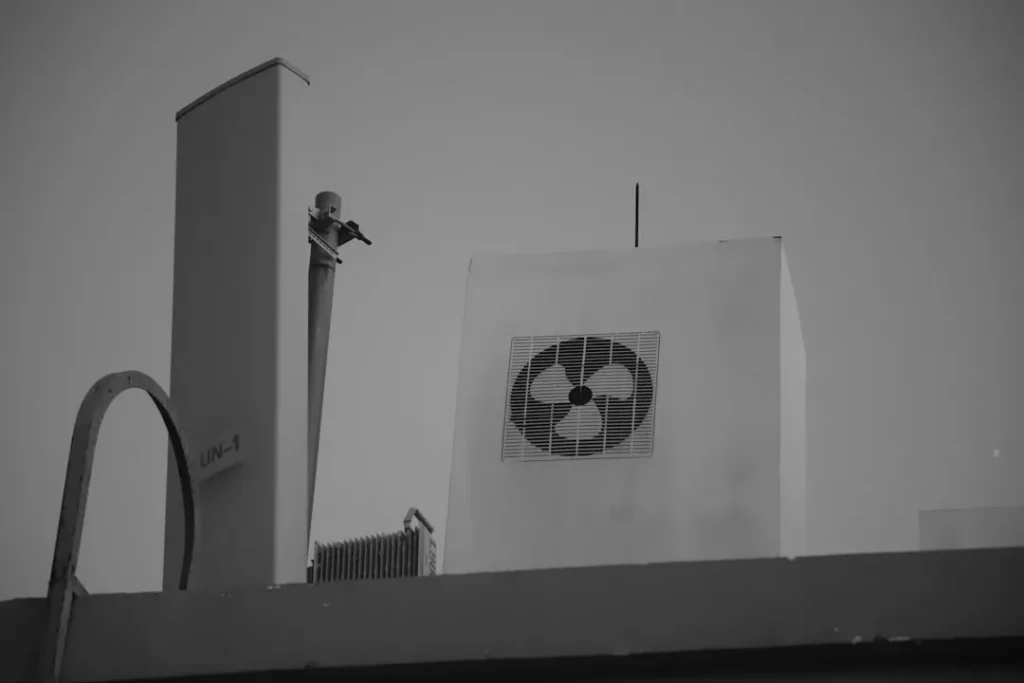 a black and white photo of a man on top of a building