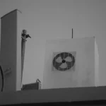 a black and white photo of a man on top of a building