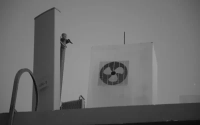 a black and white photo of a man on top of a building